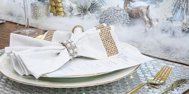 Holiday appetizer spread on sparkling charger plates with festive garnishes and candles