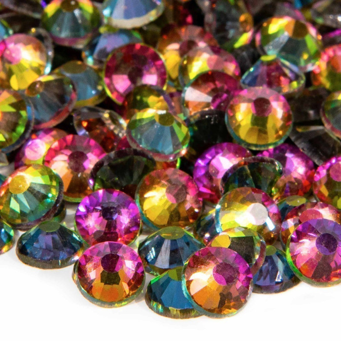 Multicolored machine cut crystal rhinestones with a faceted surface featuring shades of pink green gold and blue.