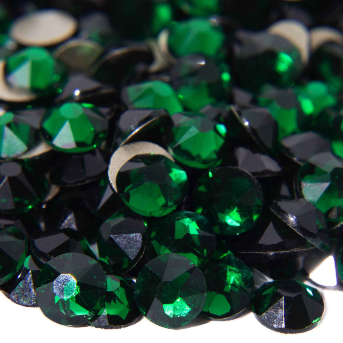 Emerald green machine-cut rhinestones with 14 facets and black flat backs showcasing high sparkle and clarity.