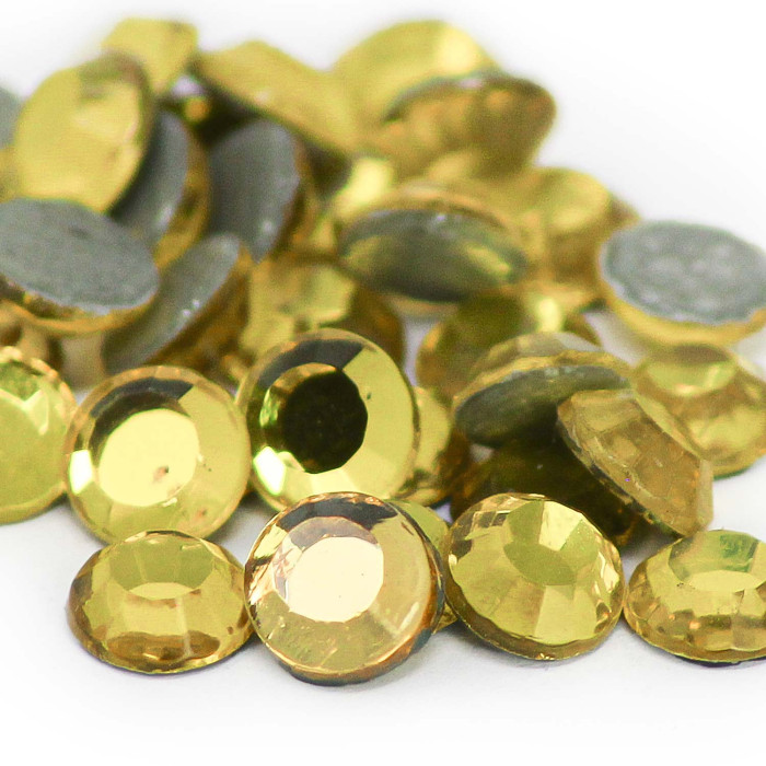 Machine cut crystal rhinestones in citrine yellow with gray glue backing featuring faceted surfaces and round shapes.