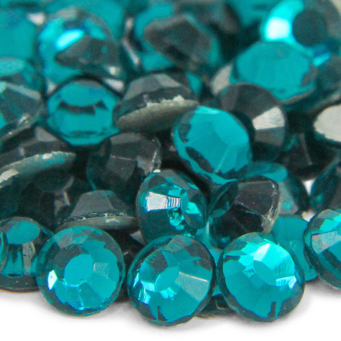 Machine cut crystal rhinestones in dark emerald green with gray glue backing featuring faceted surfaces and smooth edges.