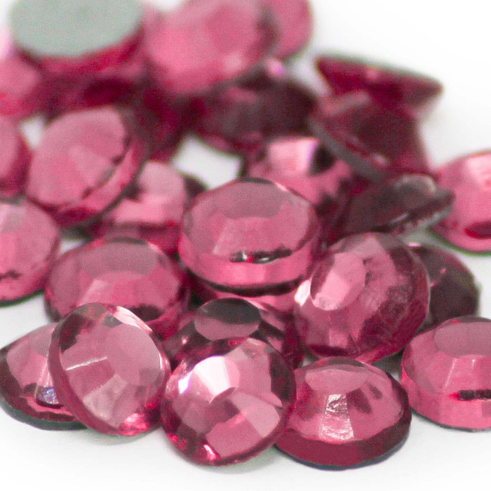 Machine cut crystal rhinestones in rose pink round shape faceted surface with a shiny finish and gray glue backing.