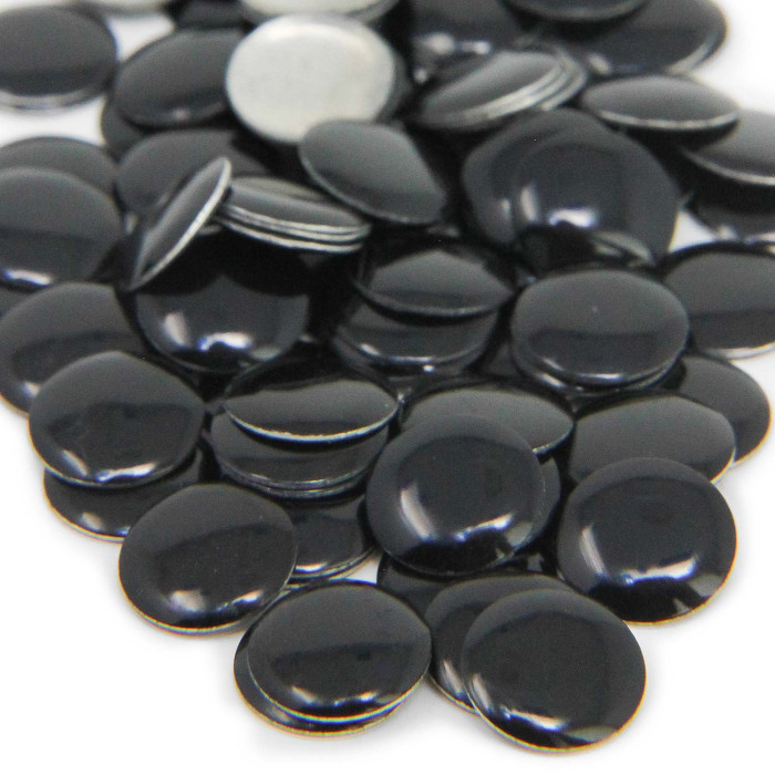 A pile of glossy black metal nailheads round and flat with a smooth surface and slight shine some with a metallic gray finish.