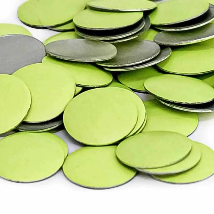 Neon yellow flat metal nailheads with a smooth surface and silver backing arranged in a scattered pile.