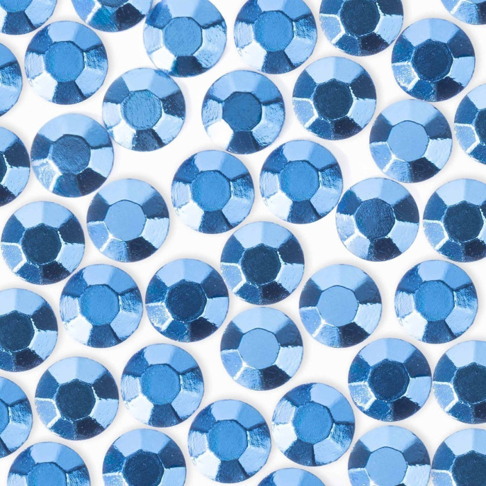 Dark blue machine-cut crystal rhinestones with a faceted surface glossy finish and circular shape arranged closely together.