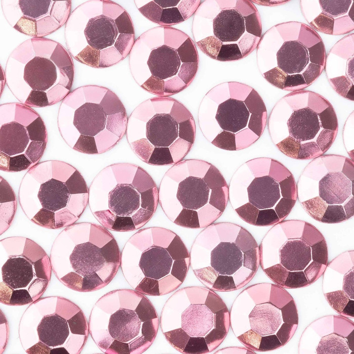 Light pink machine-cut crystal rhinestones with faceted surfaces and a glossy finish arranged closely together.
