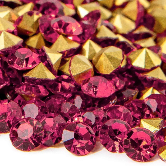 Deep pink round rhinestones mixed with gold pointed-back stones showcasing facets for sparkle and shine.