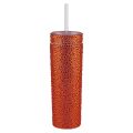 A tall silver tumbler covered in rhinestones with a clear straw and a smooth shiny surface.