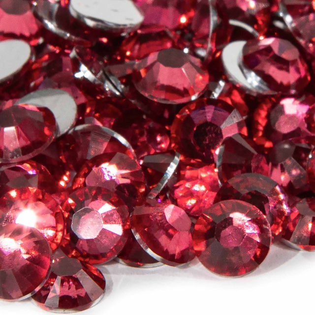 Fuchsia resin stones with faceted surfaces and silver backing varying in size reflecting light with a sparkling effect.