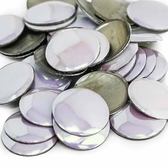 Flat round metal nailheads in iridescent purple and silver with a shiny surface and metallic edges arranged in a scattered pile.