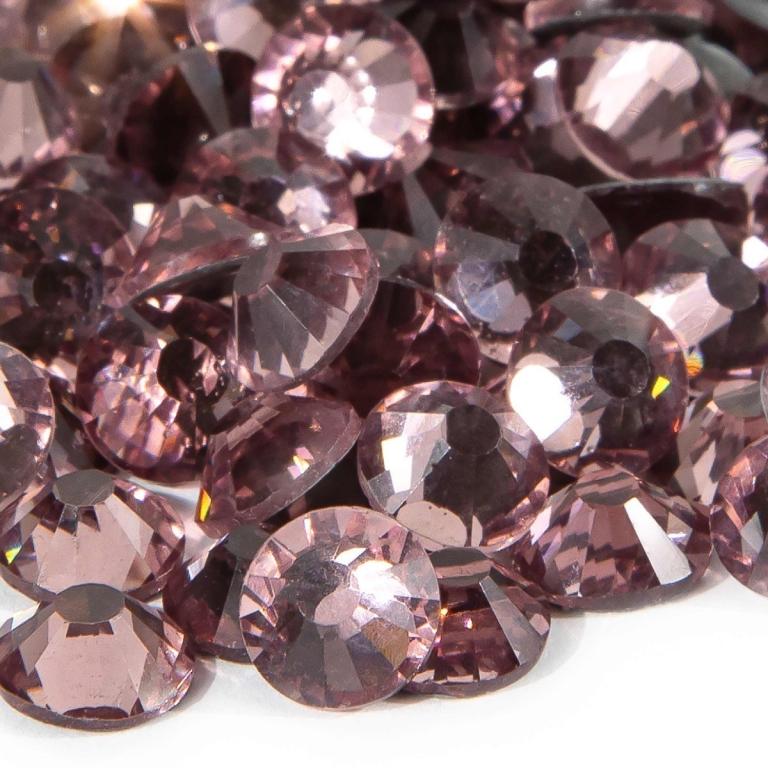 A&#x20;pile&#x20;of&#x20;round&#x20;light&#x20;amethyst&#x20;flatback&#x20;rhinestones&#x20;with&#x20;12-16&#x20;facets&#x20;and&#x20;silver&#x20;metal&#x20;backing&#x20;displaying&#x20;a&#x20;sparkling&#x20;finish.