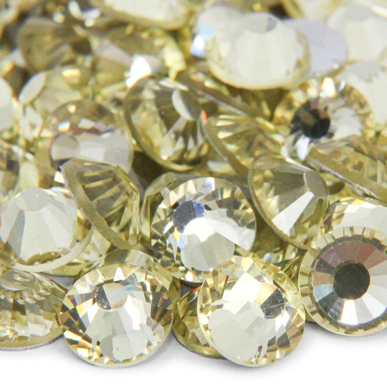 Machine cut crystal rhinestones in light yellow with faceted surfaces and black centers featuring a flat back for application.