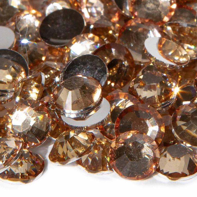 A pile of round topaz resin stones with faceted surfaces featuring silver backing and varying shades of amber and gold.