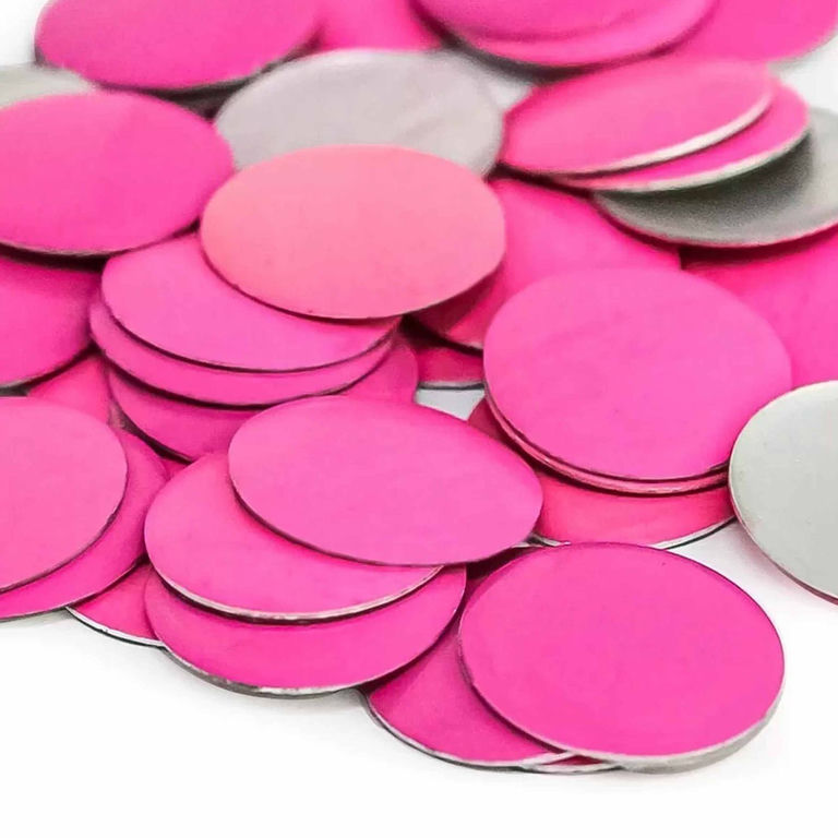 A pile of flat round neon pink metal nailheads with a shiny silver backing varying in shades of pink.