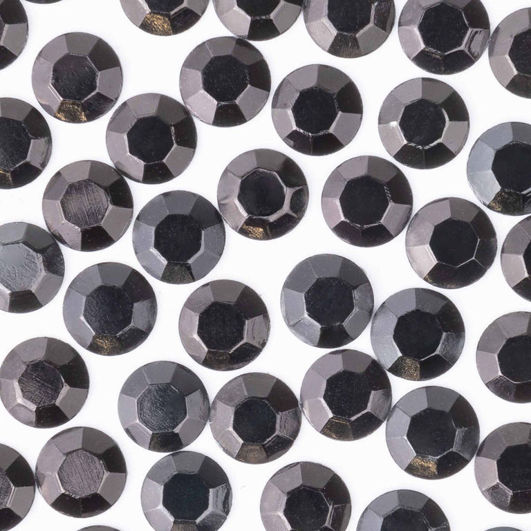 Black machine-cut crystal rhinestones with a faceted surface featuring a glossy finish and varying shades of black.