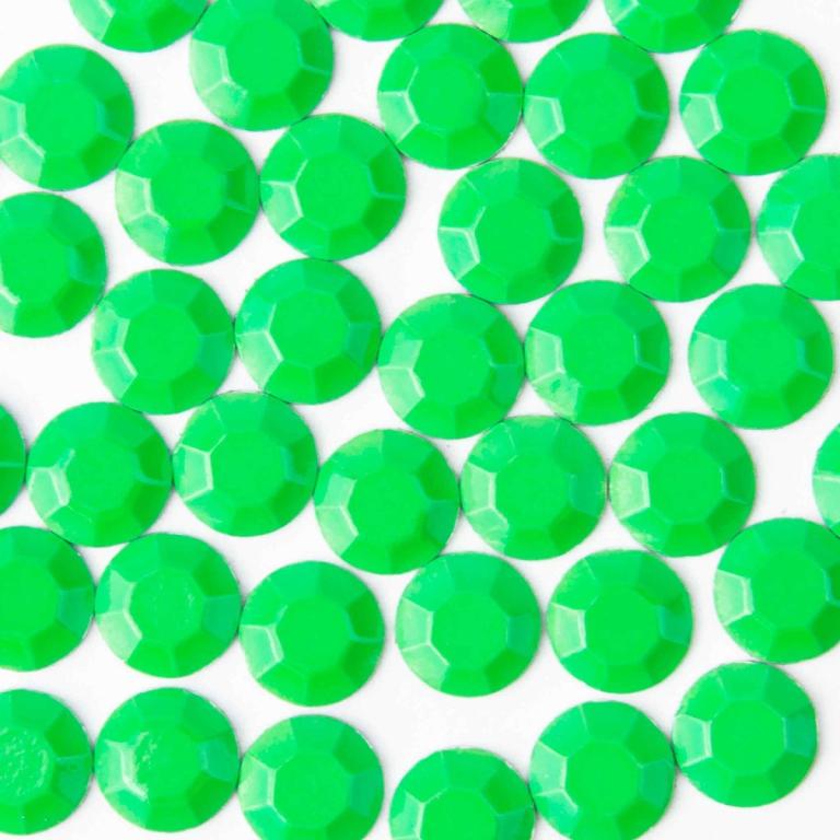 Neon green machine-cut crystal rhinestones with a faceted surface glossy finish and circular shape arranged closely together.