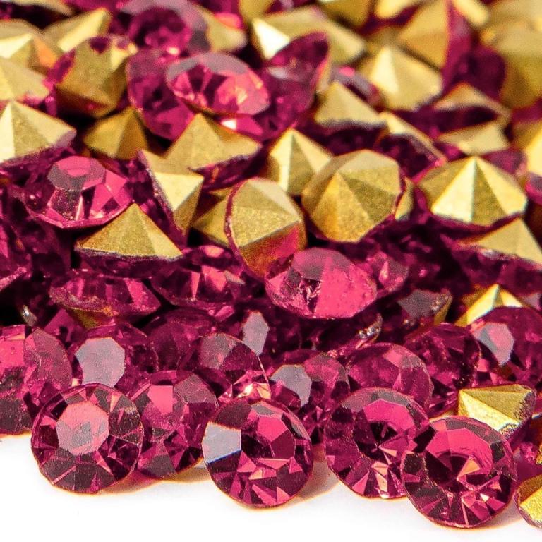 Deep pink round rhinestones mixed with gold pointed-back stones showcasing facets for sparkle and shine.