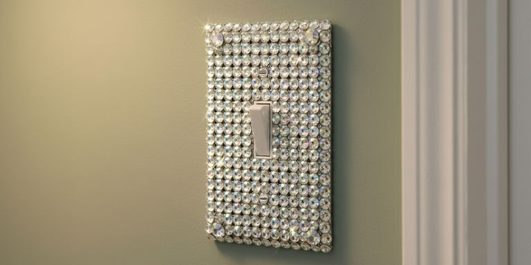 Finished rhinestone-covered light switch plate on a pale green wall