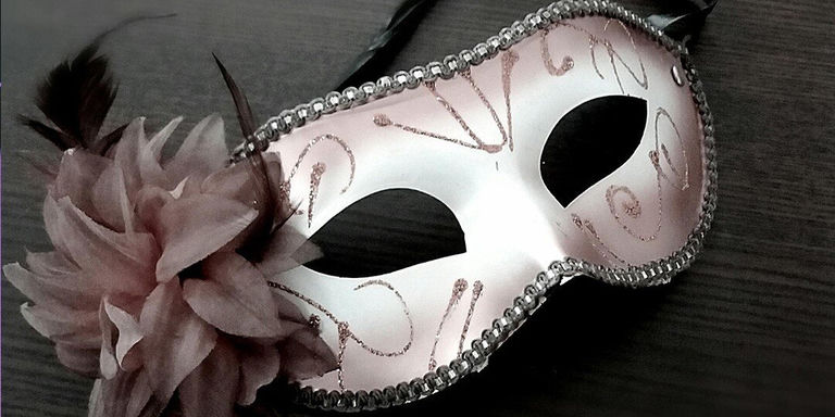 Pink masquerade mask with rhinestone trim, feathers, and glitter details