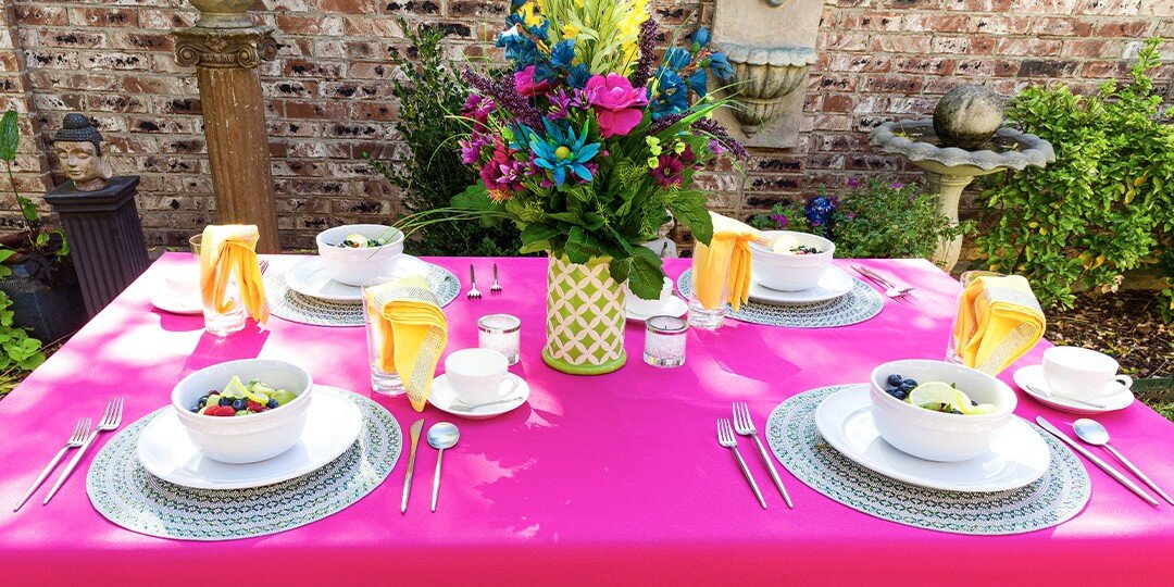 Outdoor&amp;&#x23;x20&#x3B;dining&amp;&#x23;x20&#x3B;setup&amp;&#x23;x20&#x3B;featuring&amp;&#x23;x20&#x3B;margarita&amp;&#x23;x20&#x3B;glasses&amp;&#x23;x20&#x3B;with&amp;&#x23;x20&#x3B;blue&amp;&#x23;x20&#x3B;rhinestone&amp;&#x23;x20&#x3B;rims,&amp;&#x23;x20&#x3B;turquoise&amp;&#x23;x20&#x3B;beaded&amp;&#x23;x20&#x3B;placemats,&amp;&#x23;x20&#x3B;yellow&amp;&#x23;x20&#x3B;napkins&amp;&#x23;x20&#x3B;with&amp;&#x23;x20&#x3B;sparkly&amp;&#x23;x20&#x3B;napkin&amp;&#x23;x20&#x3B;rings,&amp;&#x23;x20&#x3B;and&amp;&#x23;x20&#x3B;grilled&amp;&#x23;x20&#x3B;corn&amp;&#x23;x20&#x3B;on&amp;&#x23;x20&#x3B;wooden&amp;&#x23;x20&#x3B;slat&amp;&#x23;x20&#x3B;table&amp;&#x23;x20&#x3B;in&amp;&#x23;x20&#x3B;natural&amp;&#x23;x20&#x3B;lighting.