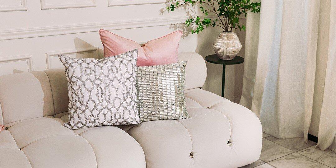 Canap&amp;&#x23;xE9&#x3B;&amp;&#x23;x20&#x3B;d&amp;&#x23;x2019&#x3B;angle&amp;&#x23;x20&#x3B;blanc&amp;&#x23;x20&#x3B;d&amp;&#x23;xE9&#x3B;cor&amp;&#x23;xE9&#x3B;&amp;&#x23;x20&#x3B;de&amp;&#x23;x20&#x3B;coussins&amp;&#x23;x20&#x3B;en&amp;&#x23;x20&#x3B;velours&amp;&#x23;x20&#x3B;rose&amp;&#x23;x20&#x3B;poudr&amp;&#x23;xE9&#x3B;,&amp;&#x23;x20&#x3B;d&amp;&#x23;x2019&#x3B;un&amp;&#x23;x20&#x3B;coussin&amp;&#x23;x20&#x3B;argent&amp;&#x23;xE9&#x3B;&amp;&#x23;x20&#x3B;&amp;&#x23;xE0&#x3B;&amp;&#x23;x20&#x3B;effet&amp;&#x23;x20&#x3B;miroir&amp;&#x23;x20&#x3B;serti&amp;&#x23;x20&#x3B;de&amp;&#x23;x20&#x3B;strass,&amp;&#x23;x20&#x3B;et&amp;&#x23;x20&#x3B;d&amp;&#x23;x2019&#x3B;un&amp;&#x23;x20&#x3B;coussin&amp;&#x23;x20&#x3B;blanc&amp;&#x23;x20&#x3B;&amp;&#x23;xE0&#x3B;&amp;&#x23;x20&#x3B;motif&amp;&#x23;x20&#x3B;treillis&amp;&#x23;x20&#x3B;argent&amp;&#x23;xE9&#x3B;.&amp;&#x23;x20&#x3B;Table&amp;&#x23;x20&#x3B;d&amp;&#x23;x2019&#x3B;appoint&amp;&#x23;x20&#x3B;noire&amp;&#x23;x20&#x3B;avec&amp;&#x23;x20&#x3B;vase&amp;&#x23;x20&#x3B;textur&amp;&#x23;xE9&#x3B;&amp;&#x23;x20&#x3B;et&amp;&#x23;x20&#x3B;feuillage,&amp;&#x23;x20&#x3B;sur&amp;&#x23;x20&#x3B;fond&amp;&#x23;x20&#x3B;de&amp;&#x23;x20&#x3B;mur&amp;&#x23;x20&#x3B;&amp;&#x23;xE0&#x3B;&amp;&#x23;x20&#x3B;panneaux&amp;&#x23;x20&#x3B;blancs&amp;&#x23;x20&#x3B;et&amp;&#x23;x20&#x3B;rideaux&amp;&#x23;x20&#x3B;fluides.