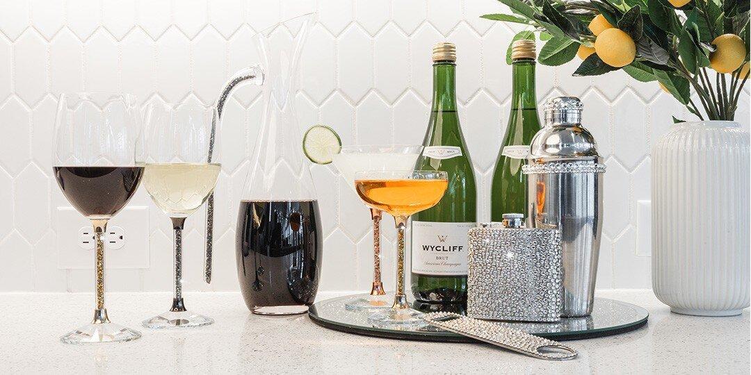 Una&amp;&#x23;x20&#x3B;elegante&amp;&#x23;x20&#x3B;configuraci&amp;&#x23;xF3&#x3B;n&amp;&#x23;x20&#x3B;de&amp;&#x23;x20&#x3B;carrito&amp;&#x23;x20&#x3B;de&amp;&#x23;x20&#x3B;bar&amp;&#x23;x20&#x3B;con&amp;&#x23;x20&#x3B;una&amp;&#x23;x20&#x3B;variedad&amp;&#x23;x20&#x3B;de&amp;&#x23;x20&#x3B;c&amp;&#x23;xF3&#x3B;cteles&amp;&#x23;x20&#x3B;y&amp;&#x23;x20&#x3B;licores.&amp;&#x23;x20&#x3B;Varios&amp;&#x23;x20&#x3B;vasos&amp;&#x23;x20&#x3B;contienen&amp;&#x23;x20&#x3B;bebidas&amp;&#x23;x20&#x3B;de&amp;&#x23;x20&#x3B;diferentes&amp;&#x23;x20&#x3B;colores,&amp;&#x23;x20&#x3B;incluyendo&amp;&#x23;x20&#x3B;vino&amp;&#x23;x20&#x3B;tinto&amp;&#x23;x20&#x3B;y&amp;&#x23;x20&#x3B;blanco,&amp;&#x23;x20&#x3B;un&amp;&#x23;x20&#x3B;c&amp;&#x23;xF3&#x3B;ctel&amp;&#x23;x20&#x3B;de&amp;&#x23;x20&#x3B;color&amp;&#x23;x20&#x3B;&amp;&#x23;xE1&#x3B;mbar&amp;&#x23;x20&#x3B;en&amp;&#x23;x20&#x3B;una&amp;&#x23;x20&#x3B;copa&amp;&#x23;x20&#x3B;de&amp;&#x23;x20&#x3B;c&amp;&#x23;xF3&#x3B;ctel&amp;&#x23;x20&#x3B;y&amp;&#x23;x20&#x3B;una&amp;&#x23;x20&#x3B;bebida&amp;&#x23;x20&#x3B;oscura.&amp;&#x23;x20&#x3B;Botellas&amp;&#x23;x20&#x3B;de&amp;&#x23;x20&#x3B;vino&amp;&#x23;x20&#x3B;verde&amp;&#x23;x20&#x3B;o&amp;&#x23;x20&#x3B;champ&amp;&#x23;xE1&#x3B;n,&amp;&#x23;x20&#x3B;una&amp;&#x23;x20&#x3B;coctelera&amp;&#x23;x20&#x3B;plateada&amp;&#x23;x20&#x3B;y&amp;&#x23;x20&#x3B;una&amp;&#x23;x20&#x3B;brillante&amp;&#x23;x20&#x3B;petaca&amp;&#x23;x20&#x3B;de&amp;&#x23;x20&#x3B;pedrer&amp;&#x23;xED&#x3B;a&amp;&#x23;x20&#x3B;est&amp;&#x23;xE1&#x3B;n&amp;&#x23;x20&#x3B;dispuestas&amp;&#x23;x20&#x3B;en&amp;&#x23;x20&#x3B;el&amp;&#x23;x20&#x3B;carrito.&amp;&#x23;x20&#x3B;Un&amp;&#x23;x20&#x3B;jarr&amp;&#x23;xF3&#x3B;n&amp;&#x23;x20&#x3B;blanco&amp;&#x23;x20&#x3B;acanalado&amp;&#x23;x20&#x3B;sostiene&amp;&#x23;x20&#x3B;una&amp;&#x23;x20&#x3B;planta&amp;&#x23;x20&#x3B;decorativa&amp;&#x23;x20&#x3B;con&amp;&#x23;x20&#x3B;peque&amp;&#x23;xF1&#x3B;as&amp;&#x23;x20&#x3B;naranjas,&amp;&#x23;x20&#x3B;y&amp;&#x23;x20&#x3B;un&amp;&#x23;x20&#x3B;fondo&amp;&#x23;x20&#x3B;blanco&amp;&#x23;x20&#x3B;geom&amp;&#x23;xE9&#x3B;trico&amp;&#x23;x20&#x3B;completa&amp;&#x23;x20&#x3B;el&amp;&#x23;x20&#x3B;estilo.