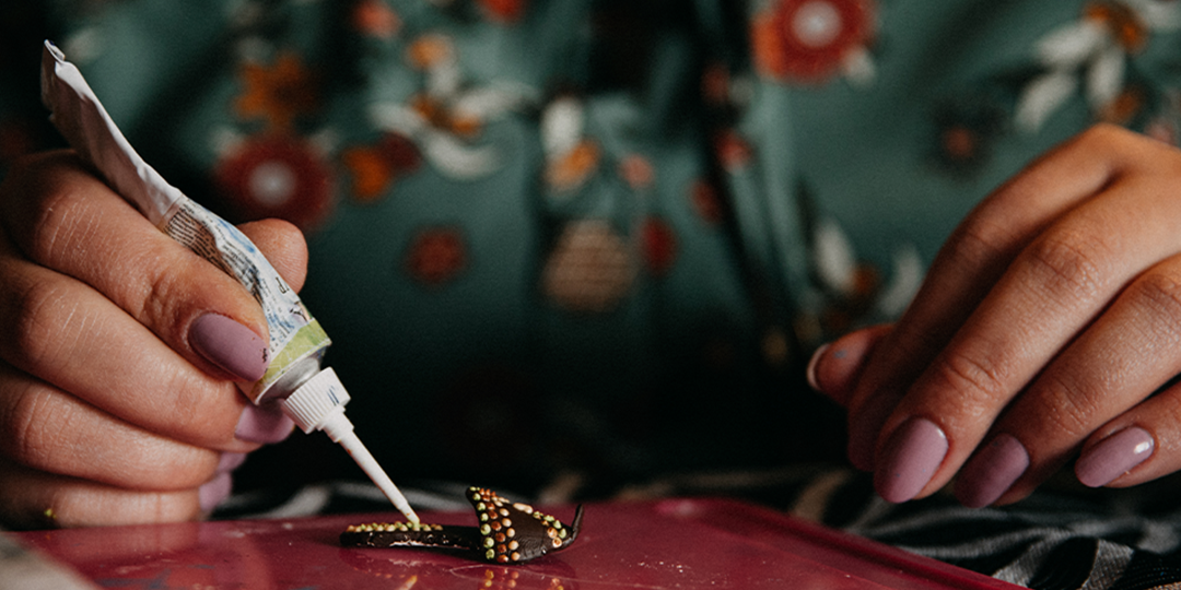 Hands&amp;&#x23;x20&#x3B;applying&amp;&#x23;x20&#x3B;rhinestones&amp;&#x23;x20&#x3B;to&amp;&#x23;x20&#x3B;jewelry&amp;&#x23;x20&#x3B;with&amp;&#x23;x20&#x3B;glue&amp;&#x23;x20&#x3B;and&amp;&#x23;x20&#x3B;tweezers