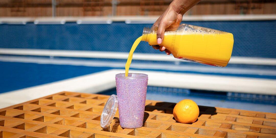 Pink&amp;&#x23;x20&#x3B;rhinestone&amp;&#x23;x20&#x3B;tumbler&amp;&#x23;x20&#x3B;being&amp;&#x23;x20&#x3B;filled&amp;&#x23;x20&#x3B;with&amp;&#x23;x20&#x3B;orange&amp;&#x23;x20&#x3B;juice&amp;&#x23;x20&#x3B;by&amp;&#x23;x20&#x3B;swimming&amp;&#x23;x20&#x3B;pool