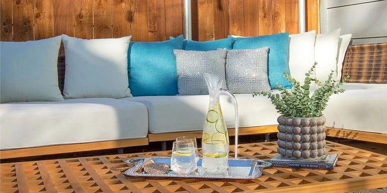 terrasse extérieure avec coussins aqua glamour, plateau miroir et carafe d’eau infusée au citron
