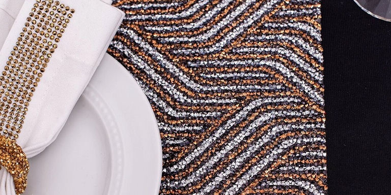 Detalle de un camino de mesa Art Deco con patrón de chevrón dorado y plateado