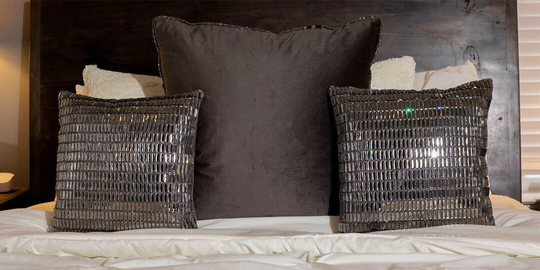 black velvet and rhinestone accent pillows on glam bedroom bed