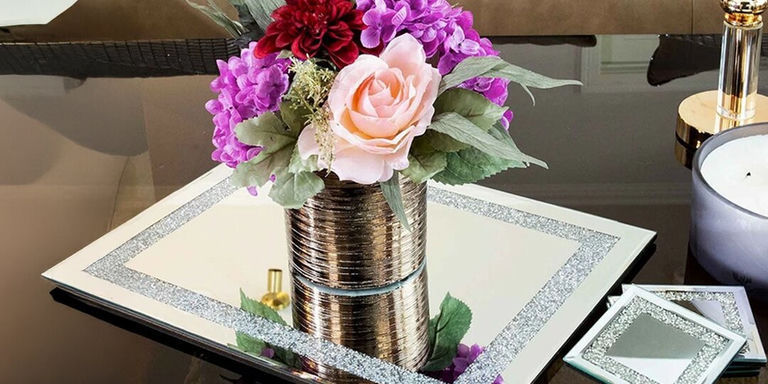 arreglo floral en mantel individual con borde de lentejuelas y velas en mesa glamurosa