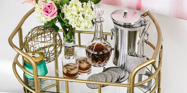 gold bar cart styled with fresh flowers, crystal decanter, rhinestone coasters, and cocktail accessories