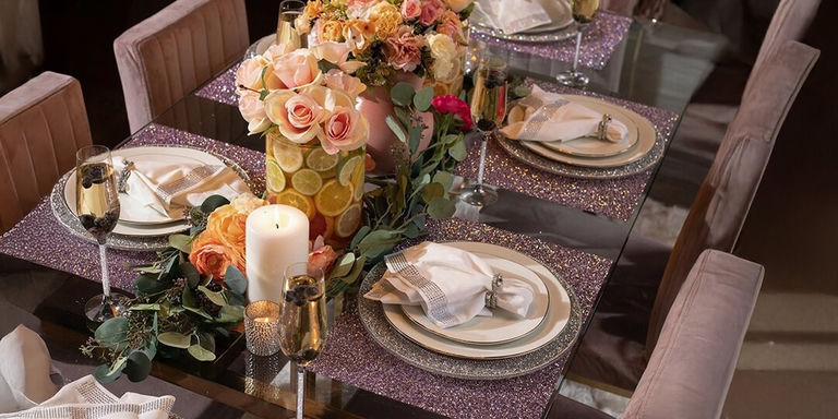 Décoration de table en soirée avec roses, centre de table aux agrumes et sets de table violets à strass pour un dîner de fête des Mères