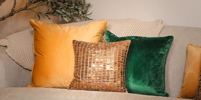 sala de estar glamurosa de otoño con cojines de pedrería dorados, verdes y bronce