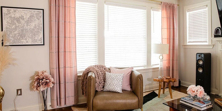 rincón acogedor de lectura con cortinas de lentejuelas rosadas y almohadas apiladas en silla de cuero