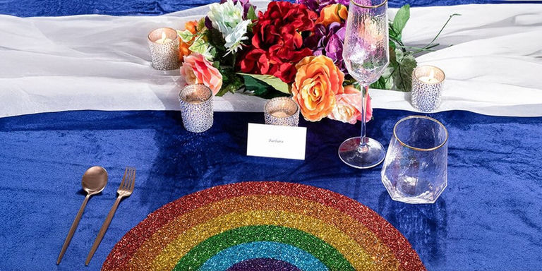 glam mesa de orgullo con mantel de arcoíris brillante, mantel de terciopelo azul, cubiertos de oro y flores de arcoíris