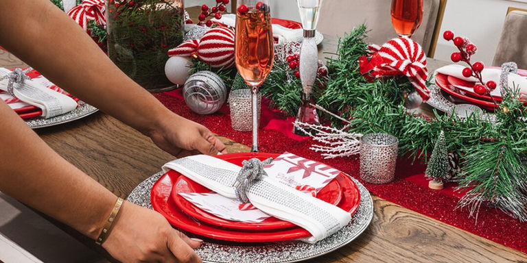 setting red plate with rhinestone napkin ring and silver charger on red holiday table