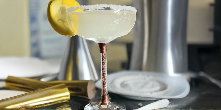 lemon drop martini with sugared rim and lemon garnish in rose gold rhinestone-stemmed coupe glass