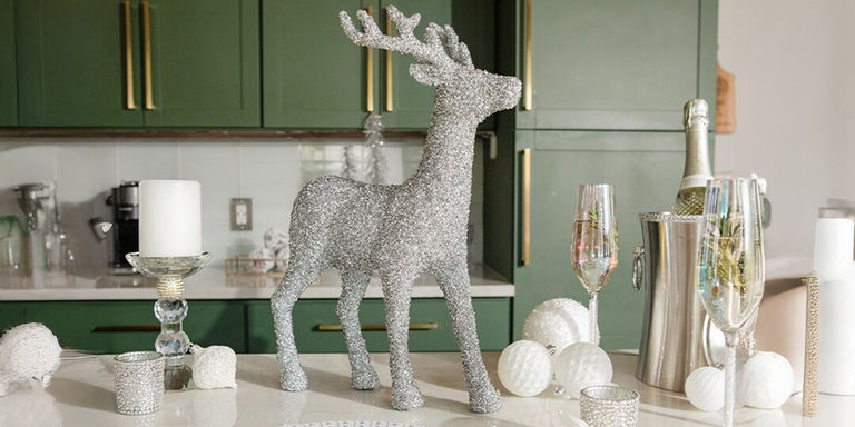 silver rhinestone-covered reindeer statue centerpiece with champagne flutes and holiday decor