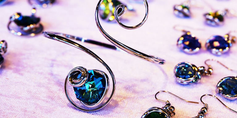 Holiday-themed rhinestone gift ideas displayed on soft fabric, including earrings and bracelets