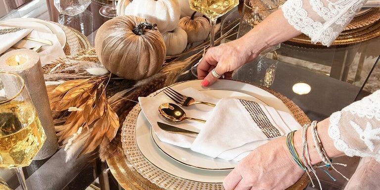 gros plan sur une serviette ornée de strass et un centre de table citrouille en velours sur une table glamour