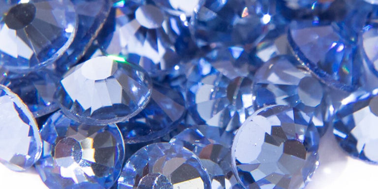 Acercamiento de brillantes diamantes de imitación azules reflejando la luz