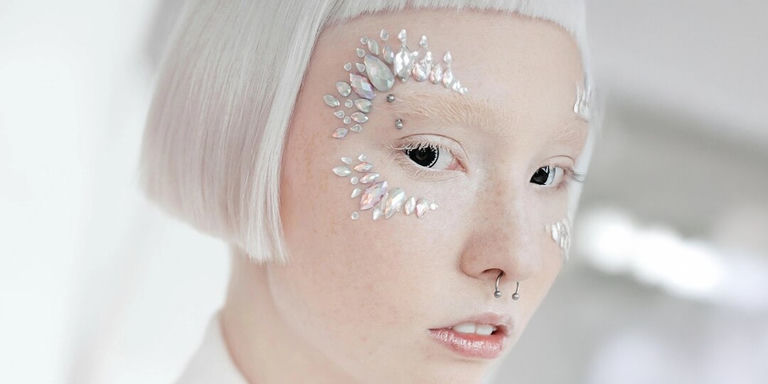 Maquillaje facial con pedrería de vanguardia utilizando resina puntiaguda y pedrerías planas para un estilo futurista