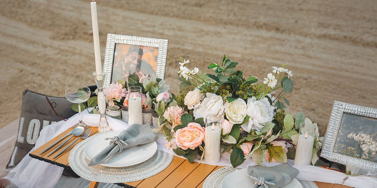 Table glamour en bord de mer avec chargeurs en strass et compositions florales